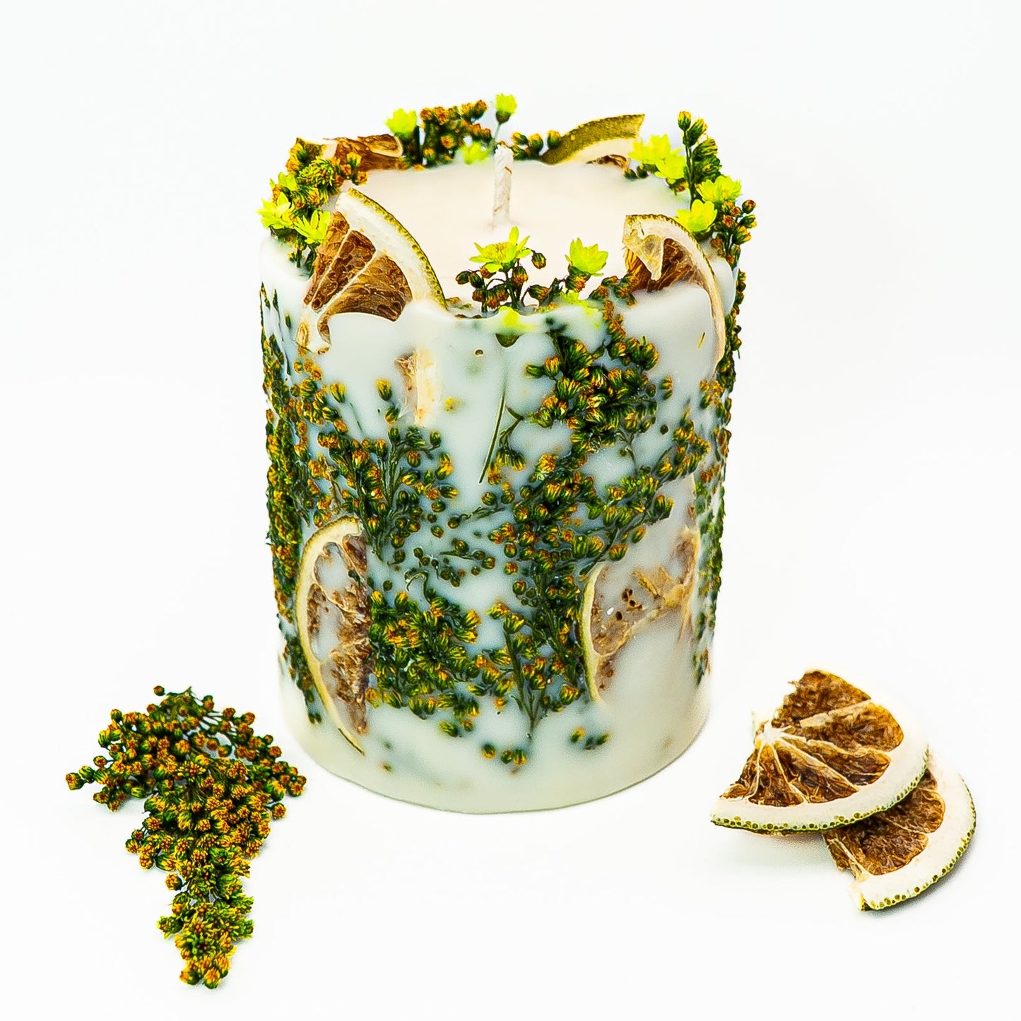 Artisan decorative soy candle with layered citrus botanicals and natural greenery.