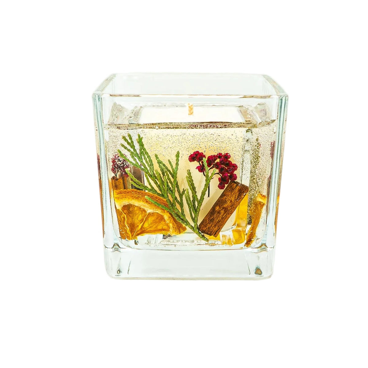 Blossoms of Eden Christmas candle with red berries, green thuja, dried orange and cinnamon surrounding an ivory soy wax core.