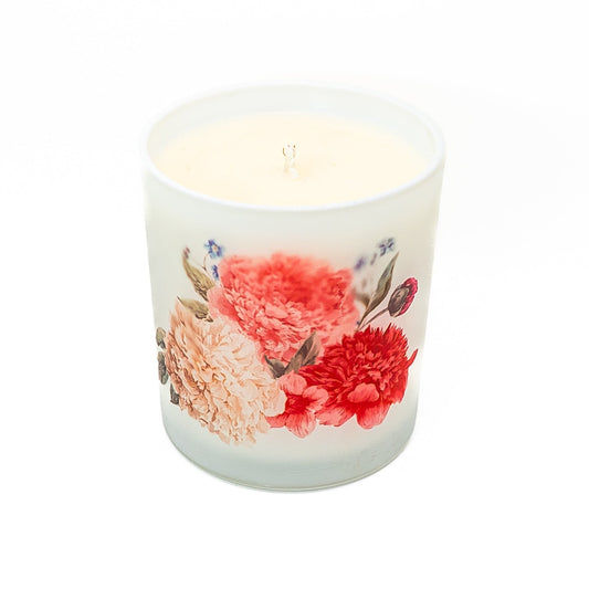 Decorative hand-poured soy wax candle in a frosted glass jar with botanical floral design.