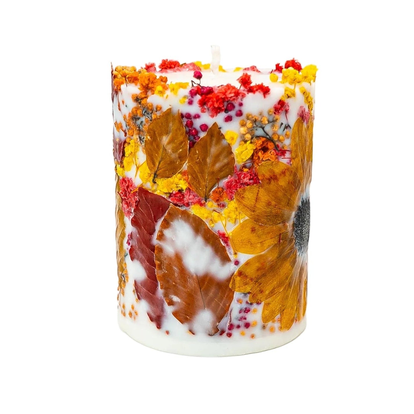 Luxury handmade autumn botanical soy wax pillar candle with a dried sunflower and natural autumn leaves on a white background.