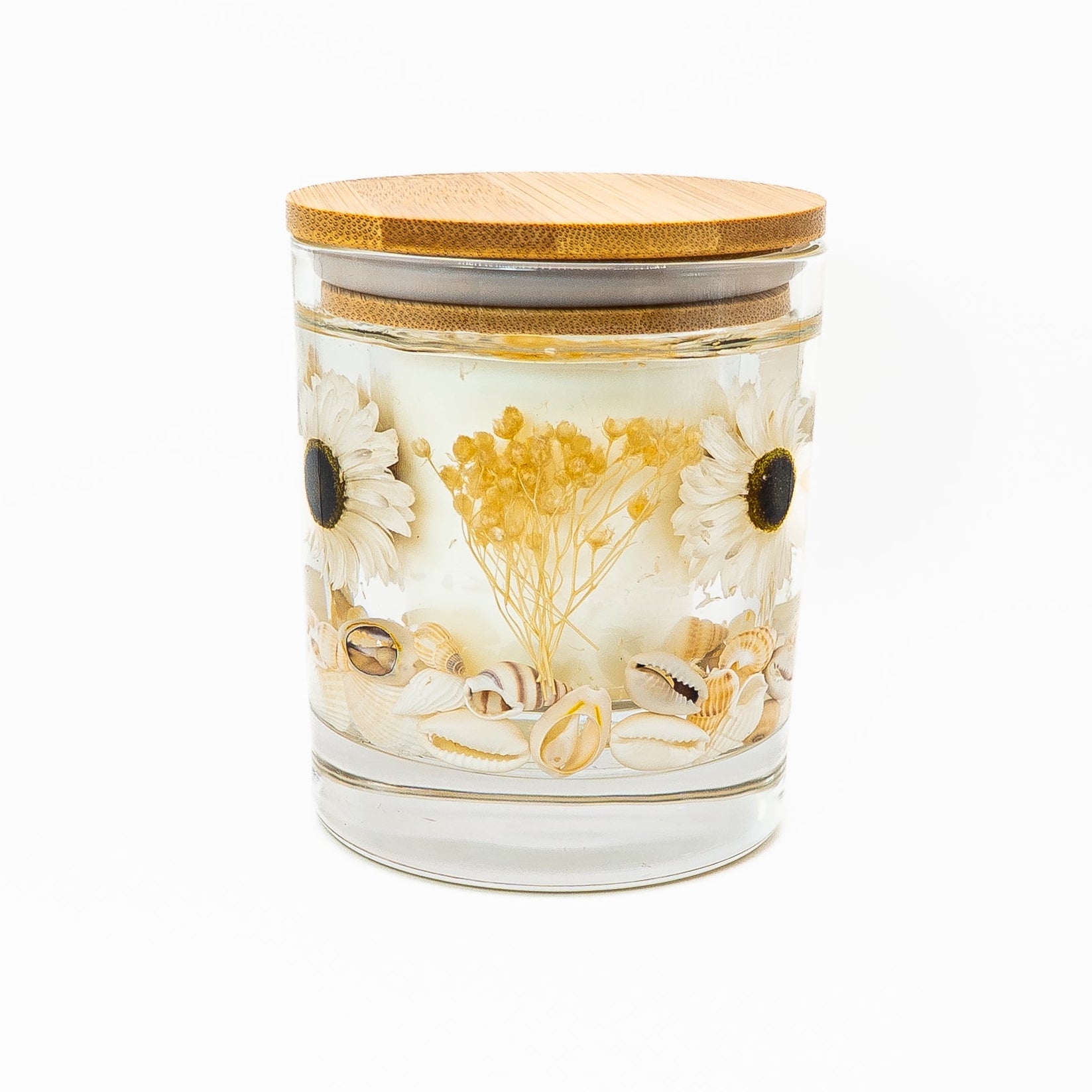 Front view of hand-poured soy wax candle with decorative gel layer featuring daisies, dried yellow flowers, and seashells.