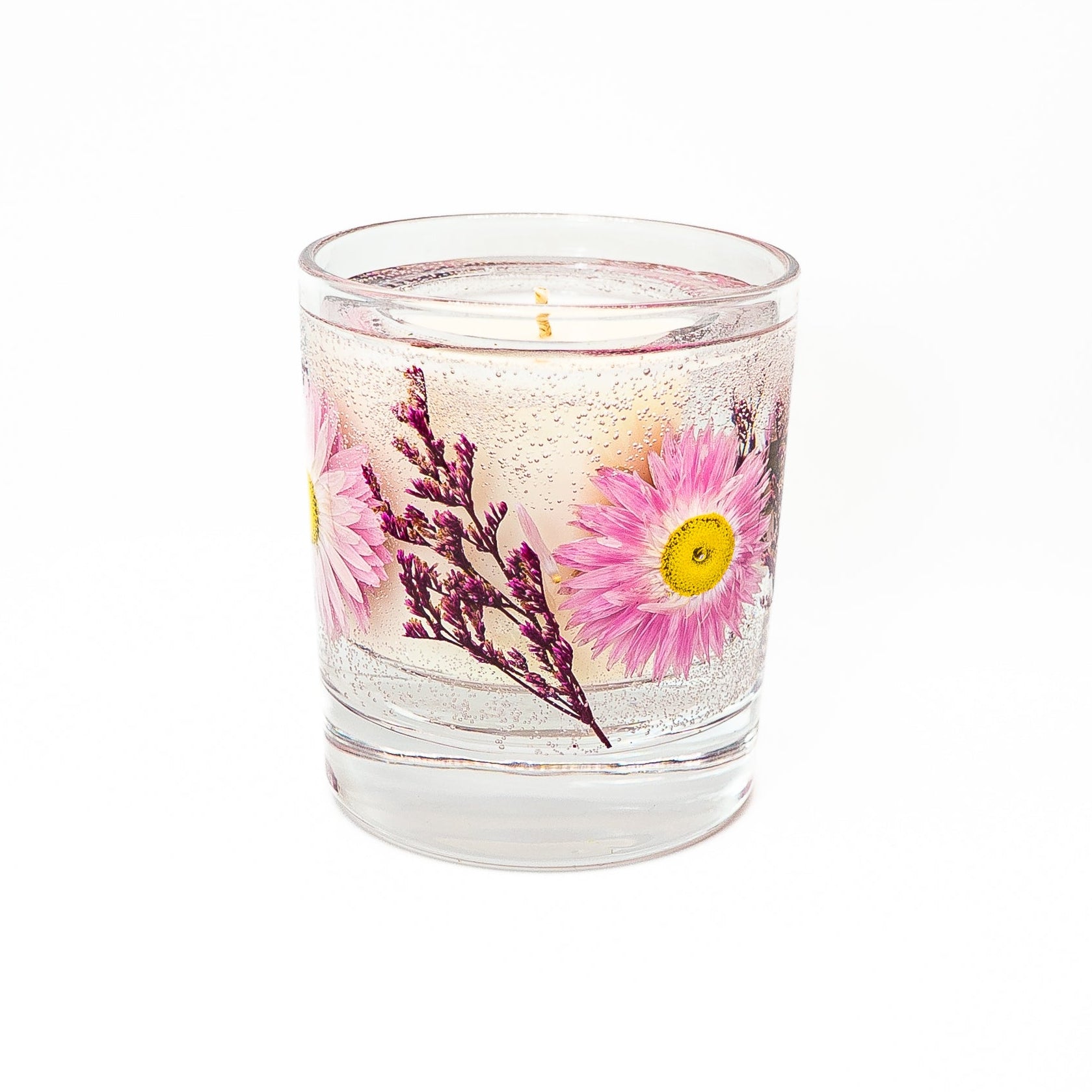 Soy wax candle with gel wax outer layer decorated with pink acroclinium everlasting daisies and dried botanical accents.