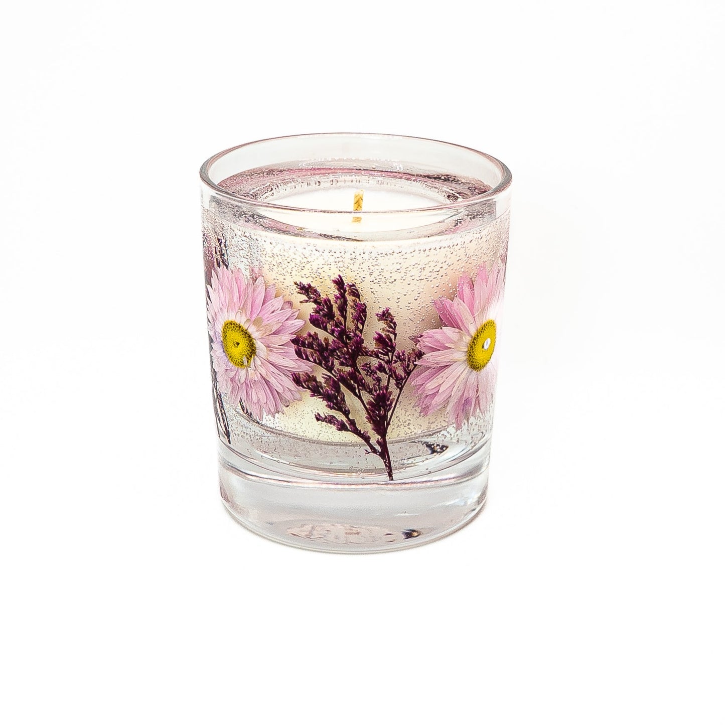 Soy wax candle with transparent gel wax decorated with pink acroclinium flowers in a glass jar with bamboo lid.