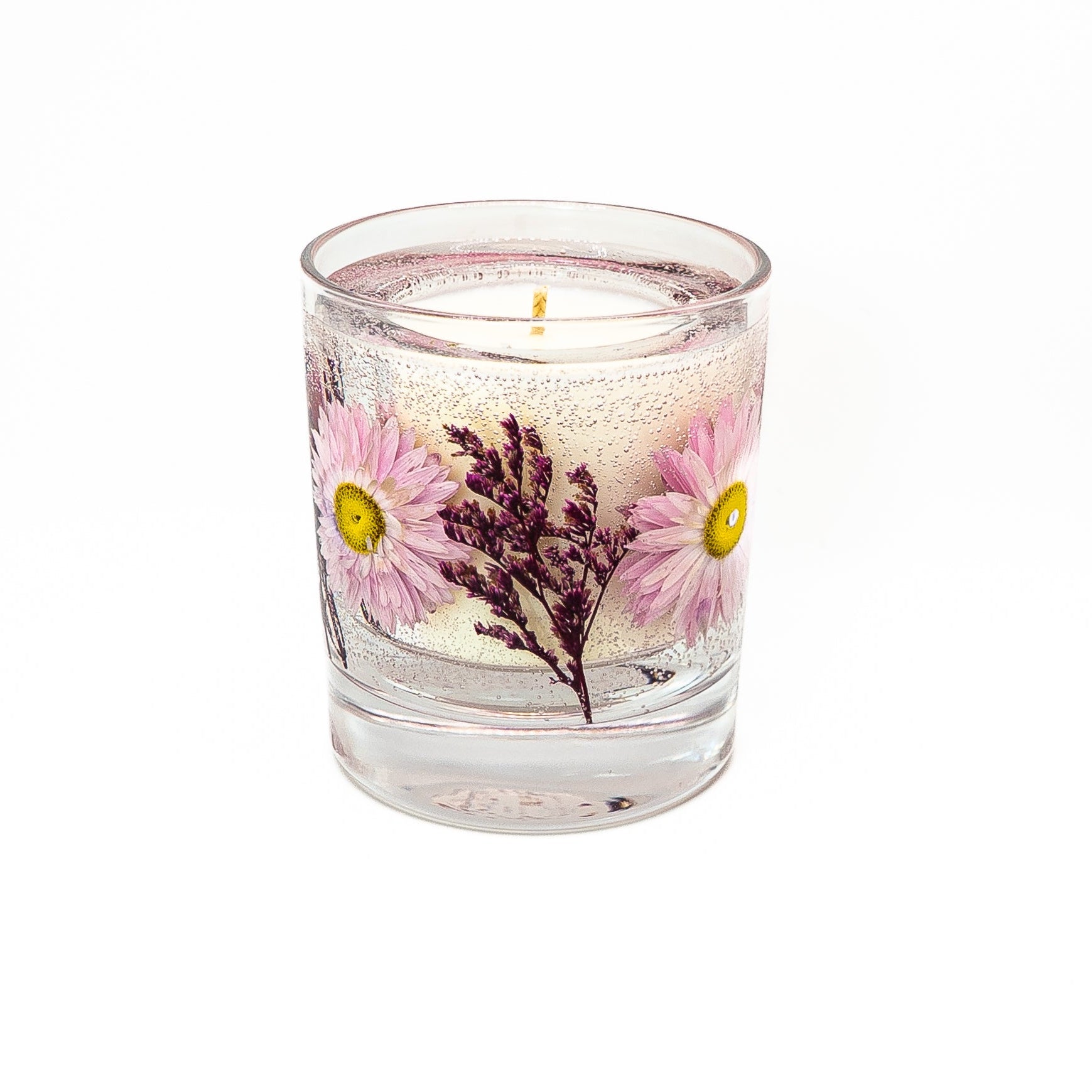 Soy wax candle with transparent gel wax decorated with pink acroclinium flowers in a glass jar with bamboo lid.