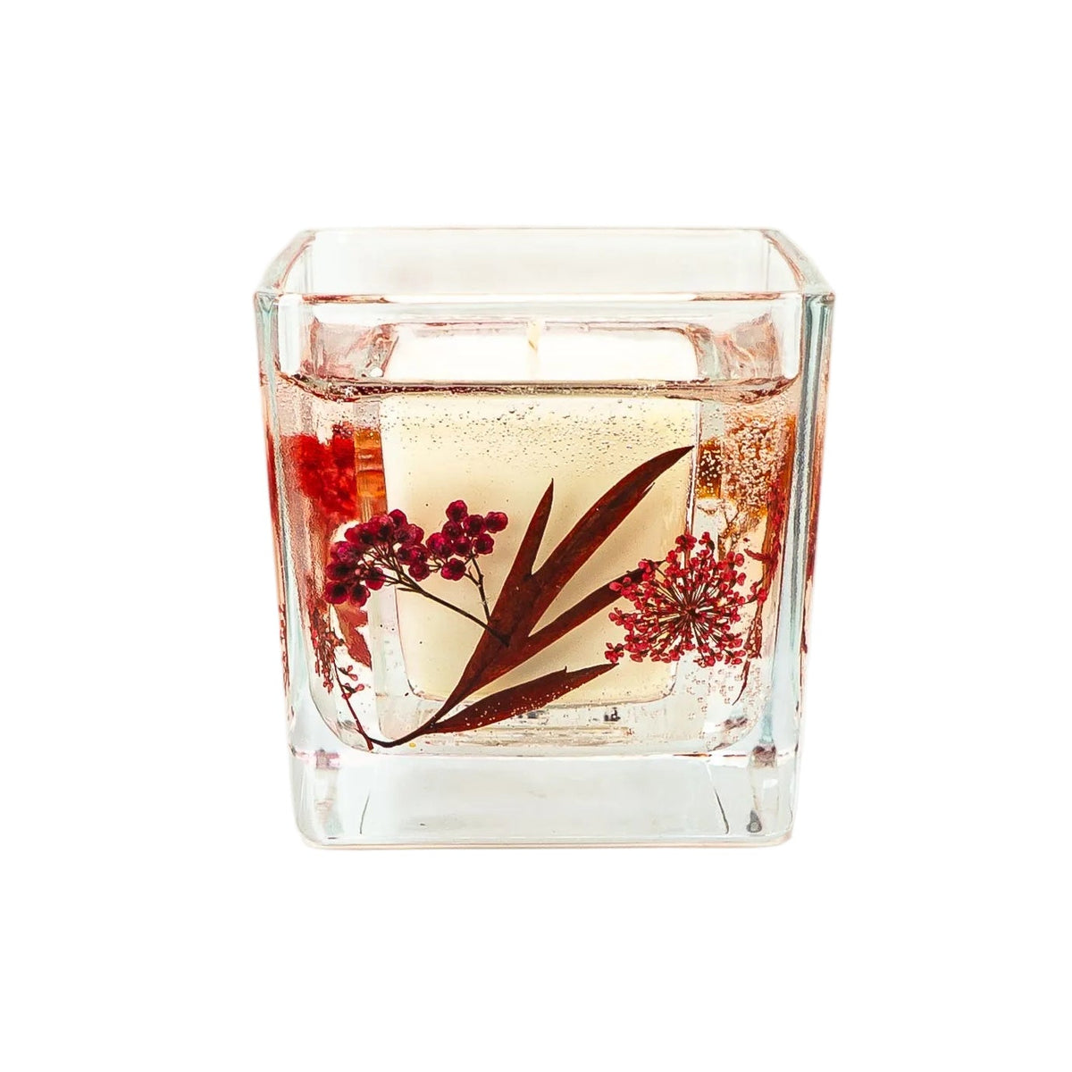 Autumn candle with dried maple leaves and flowers for home décor and gifting.