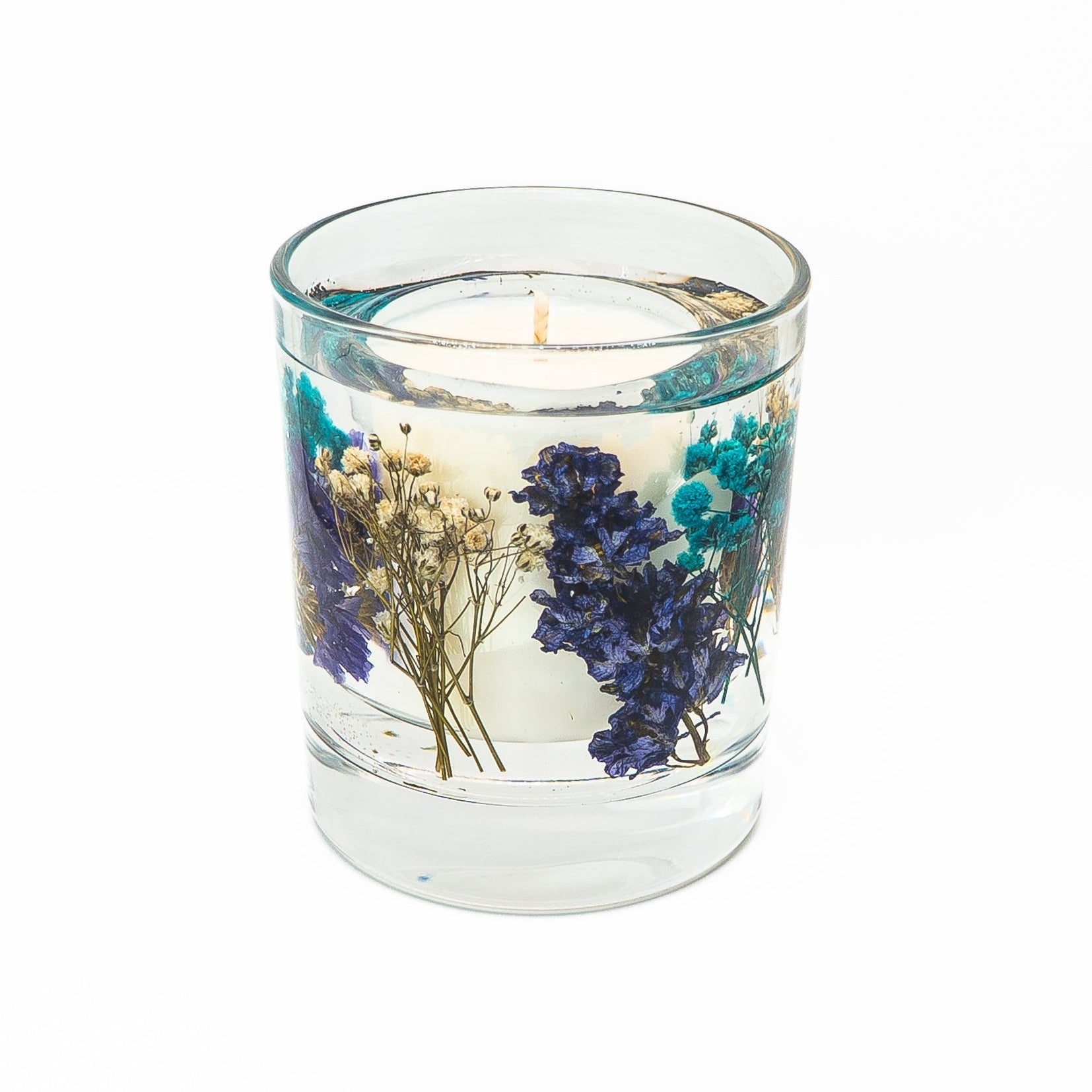 Soy wax candle with clear gel wax layer decorated with blue floral botanicals and dried flowers.