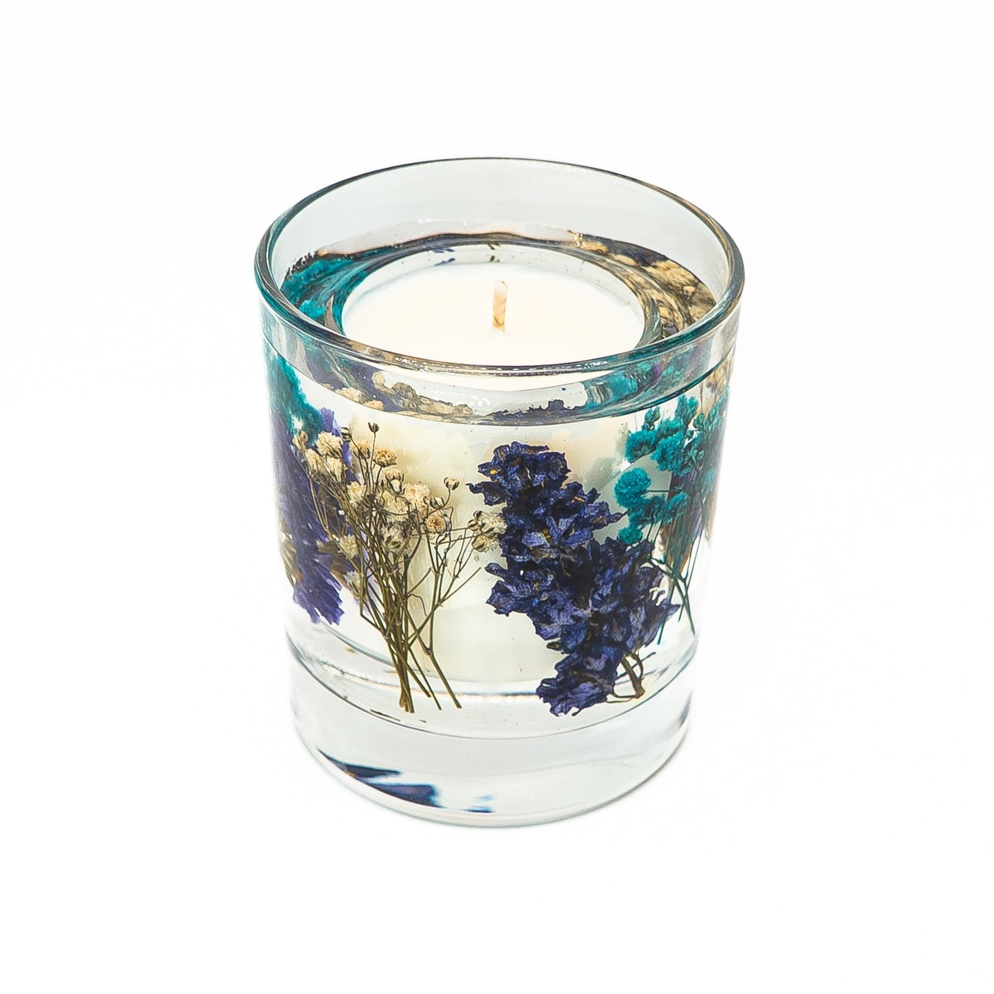 Soy wax candle with gel wax outer layer decorated with blue dried flowers and botanical elements.