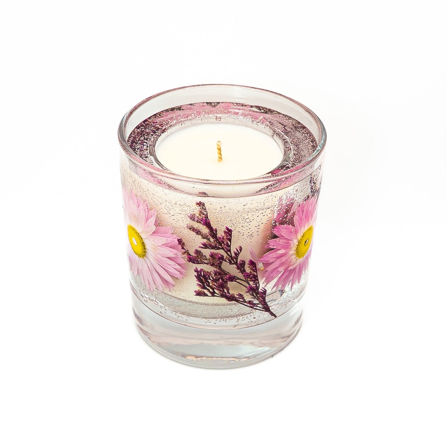 Floral soy wax candle with clear gel wax containing preserved pink acroclinium flowers and purple dried botanicals.