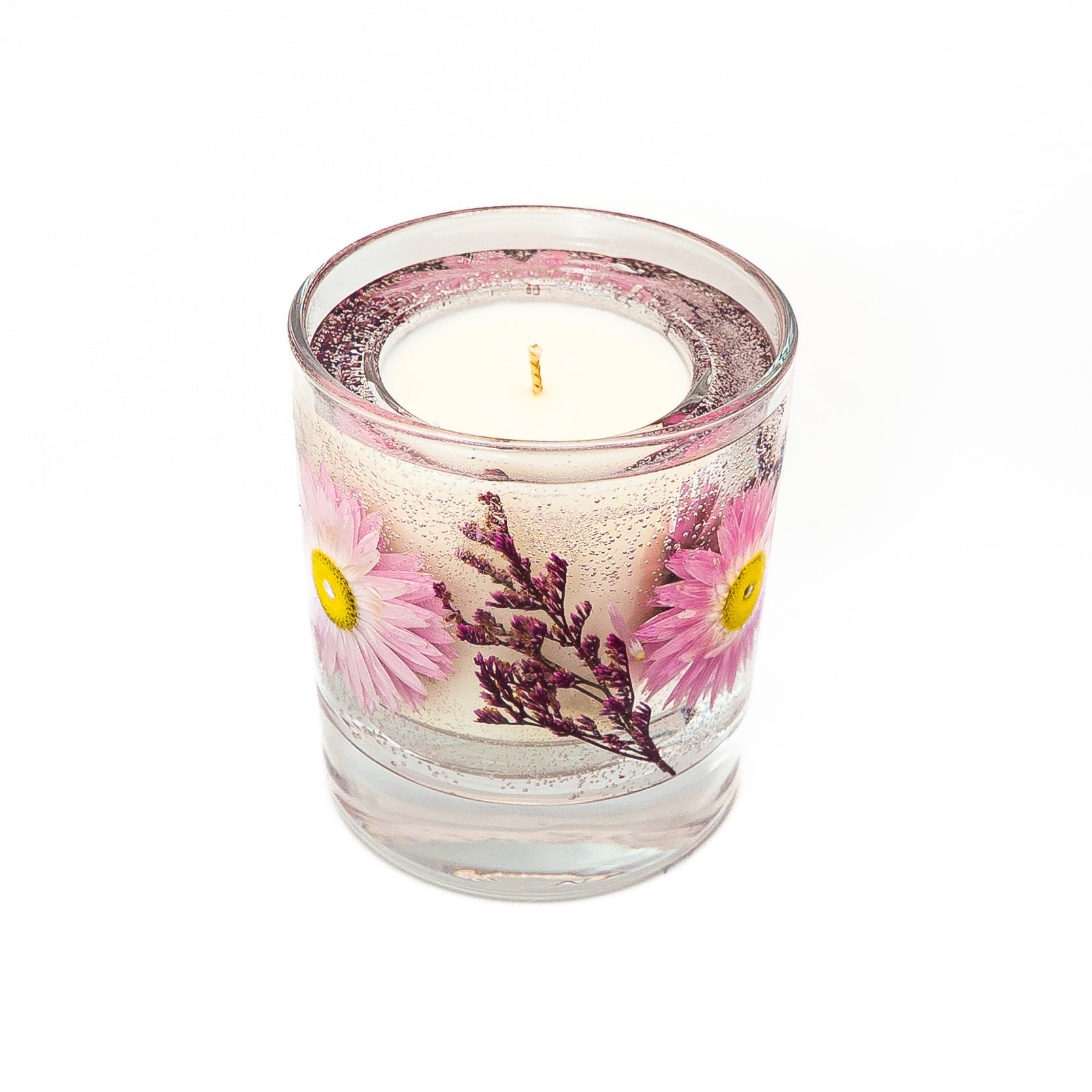 Floral soy wax candle with clear gel wax containing preserved pink acroclinium flowers and purple dried botanicals.