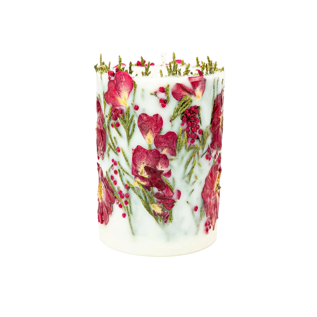 Side of a handmade botanical candle with red berries, small red petals and thuja sprigs.