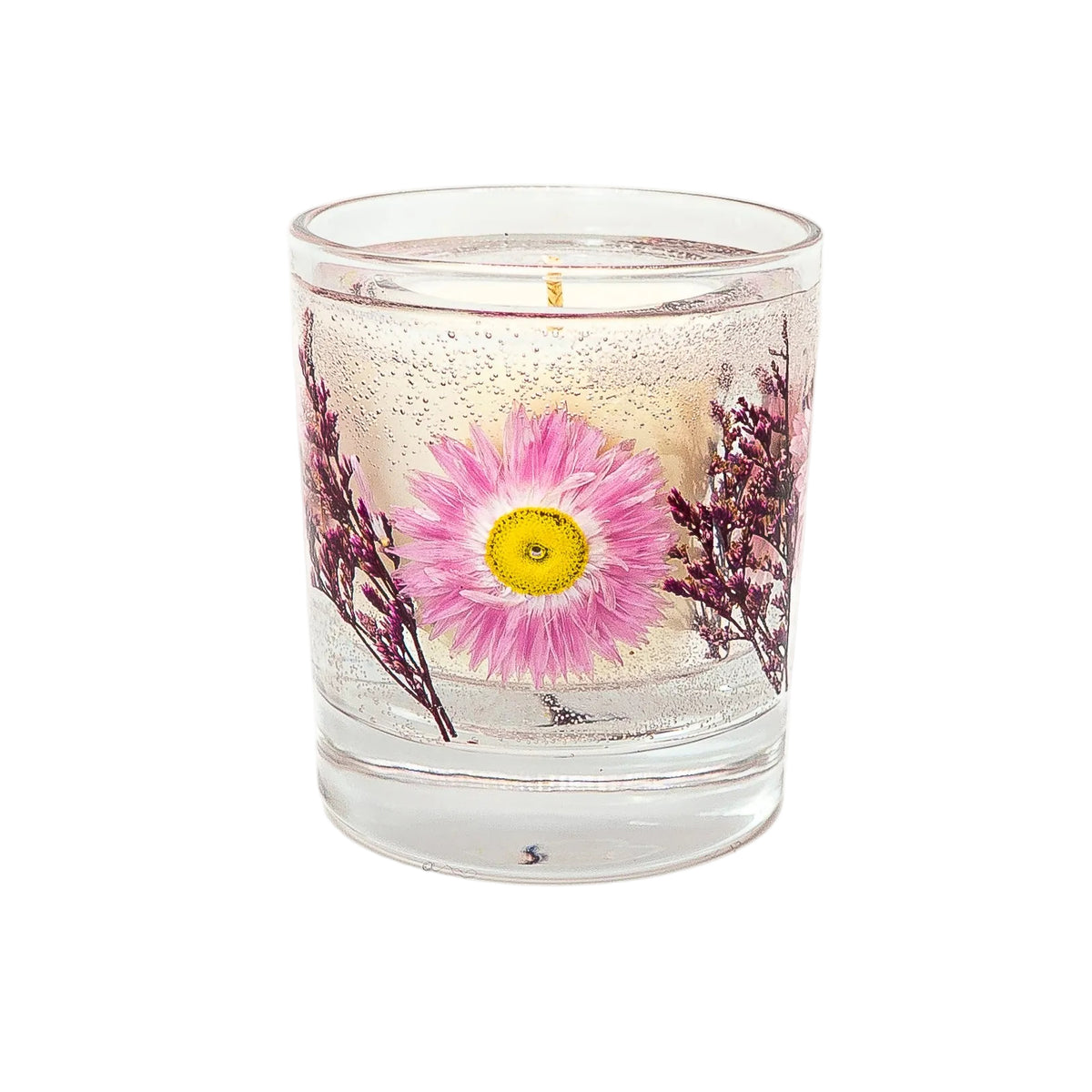 Front view of a botanical candle with a soy wax centre, pink flower and purple foliage in a clear gel wax outer layer.