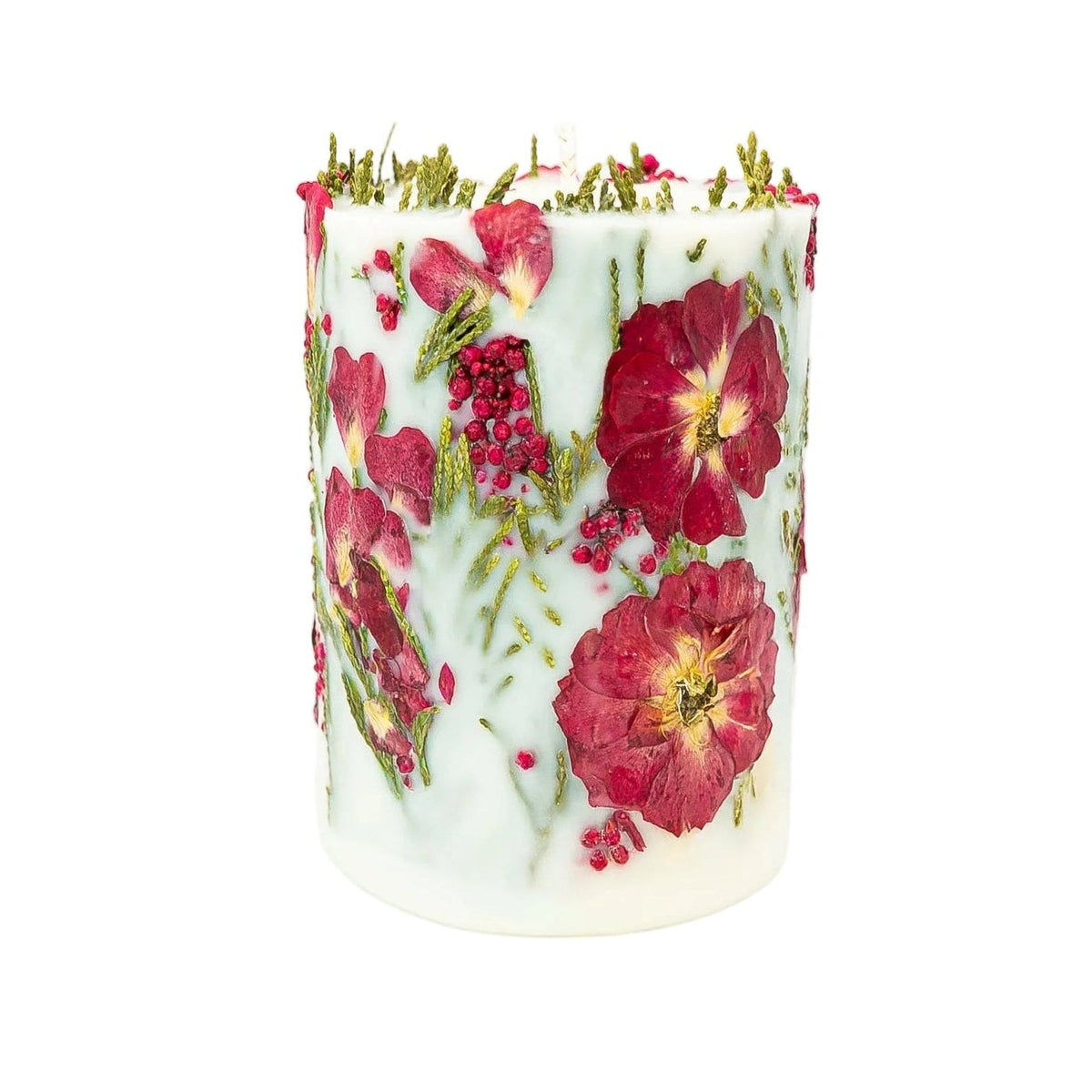 Handmade Christmas botanical soy pillar candle with dried red flowers, berries and green thuja set in creamy white wax.
