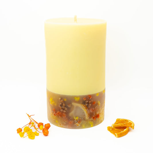Layered soy wax candle with smooth yellow top and decorative citrus botanical base.