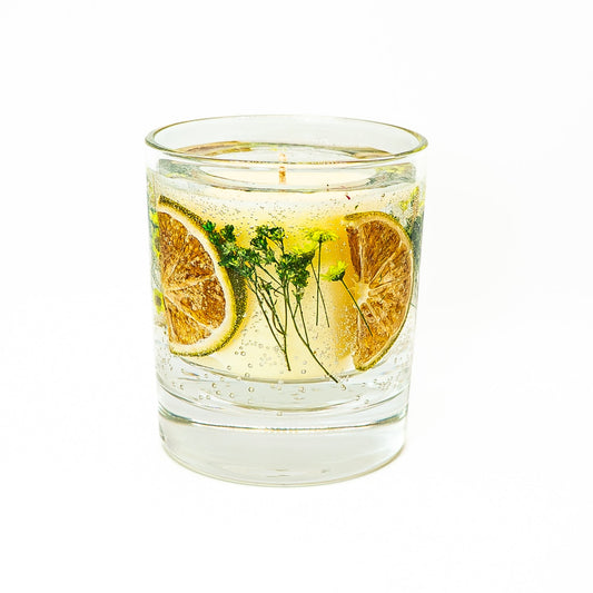 Decorative soy wax candle with transparent gel wax containing dried citrus fruit slices and delicate botanical stems.