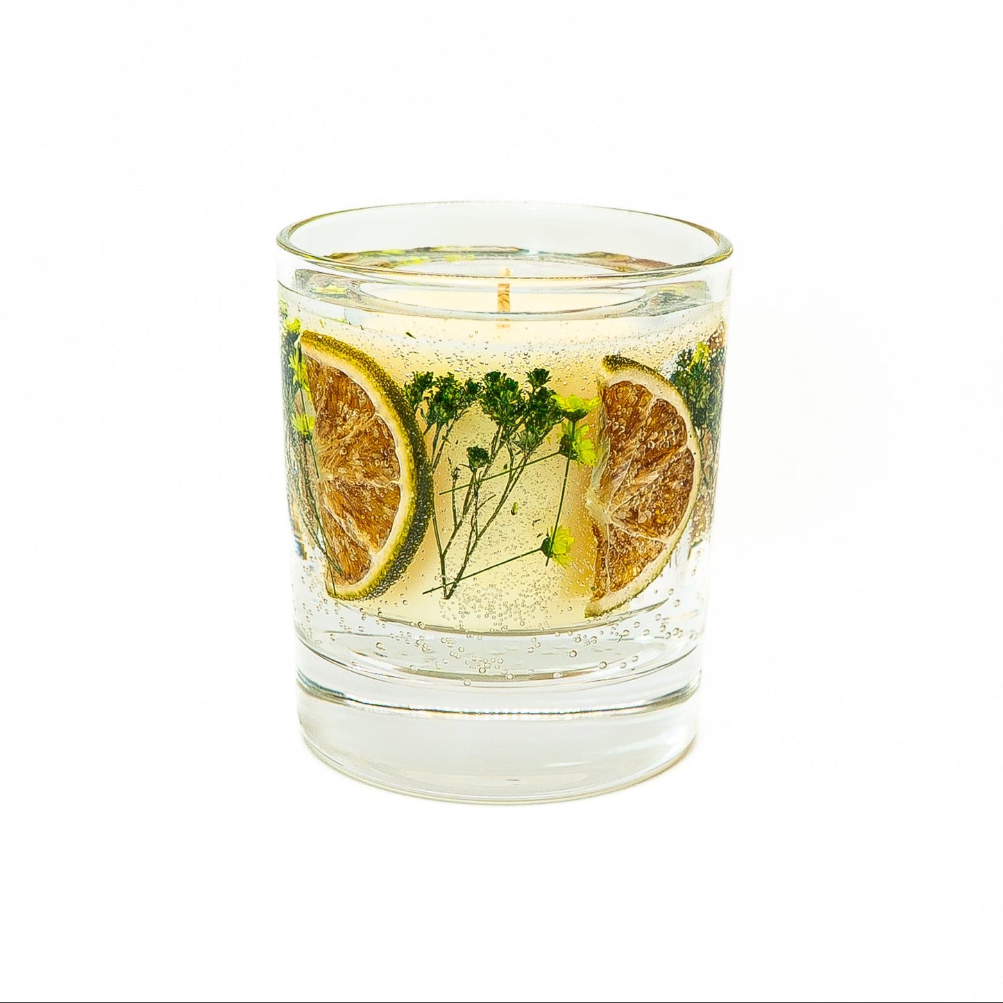 Decorative soy wax candle with clear gel wax decorated with dried citrus slices and natural herbal botanicals.