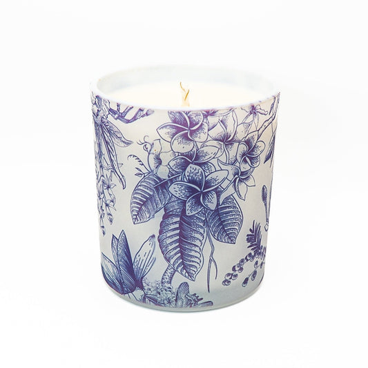 Decorative blue botanical soy wax candle in a glass container with bamboo lid and detailed floral illustration design.