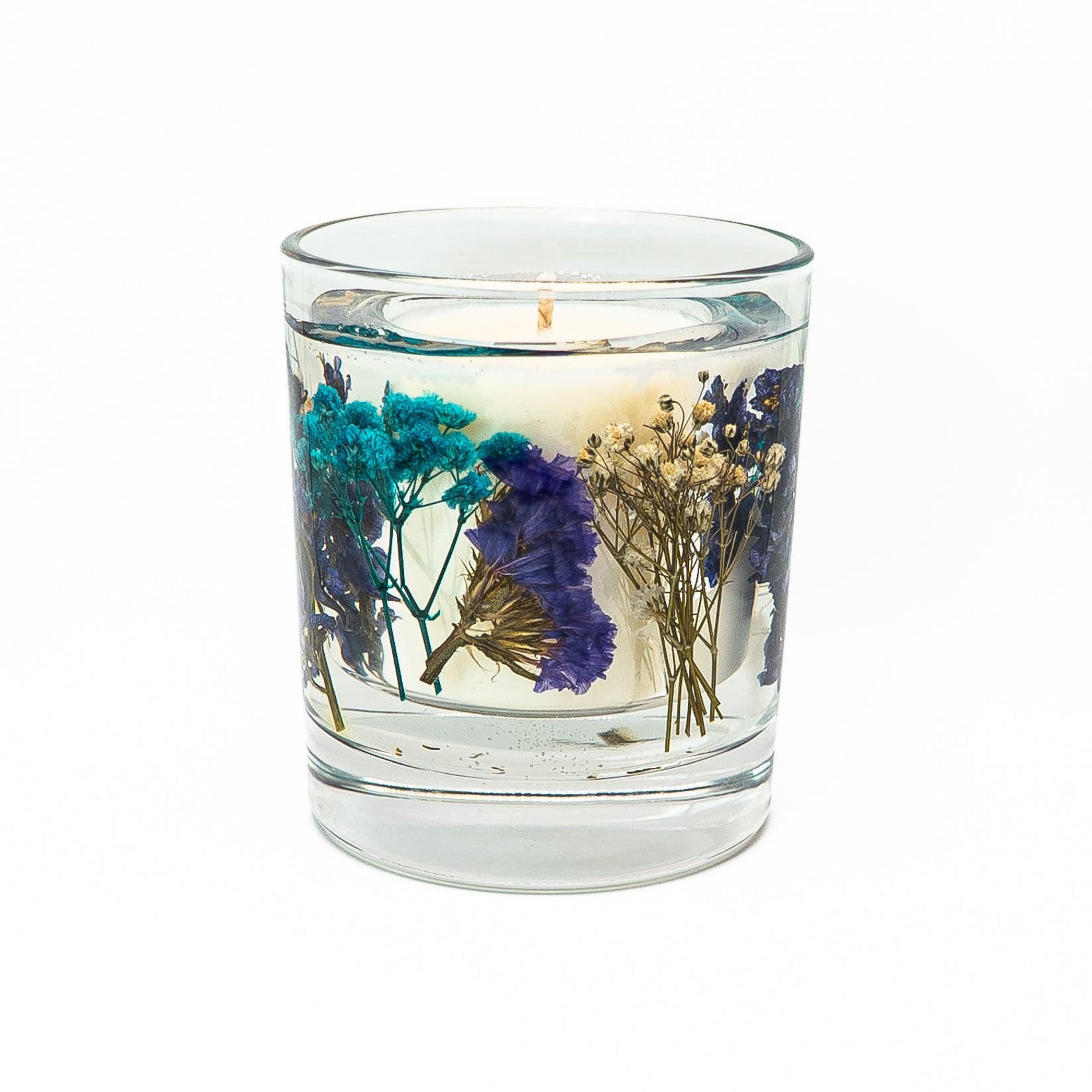 Decorative soy wax candle with gel wax featuring preserved blue flowers in a glass jar with bamboo lid.