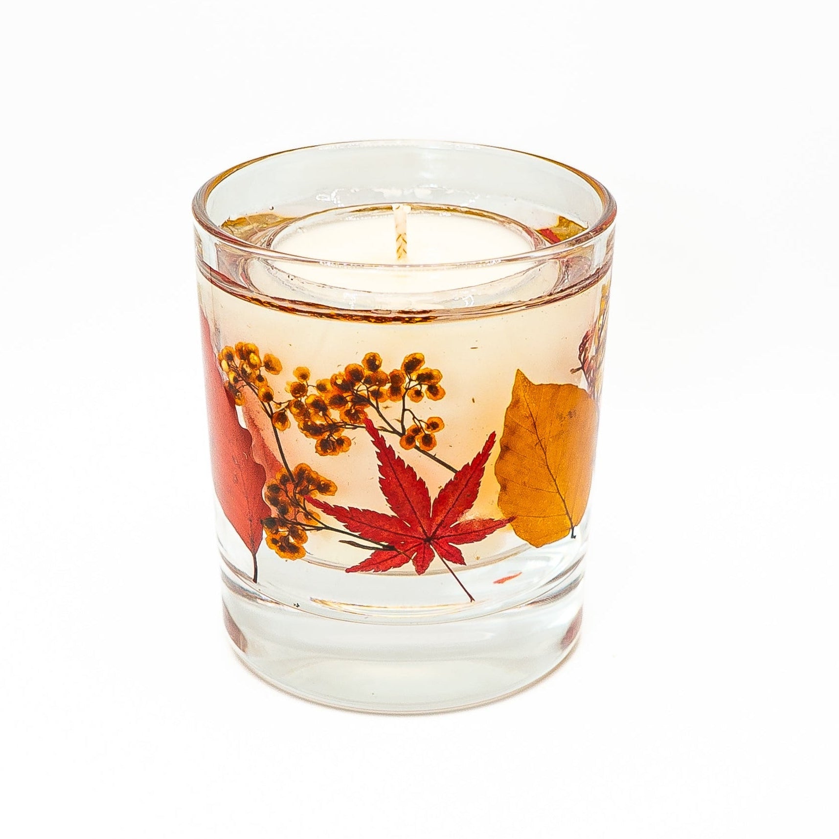 Soy wax and gel wax candle featuring preserved autumn leaves and dried botanical decorations.