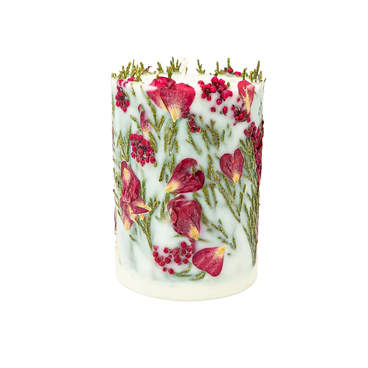 Side of a handmade botanical candle decorated with red berries, small red petals and thuja sprigs.