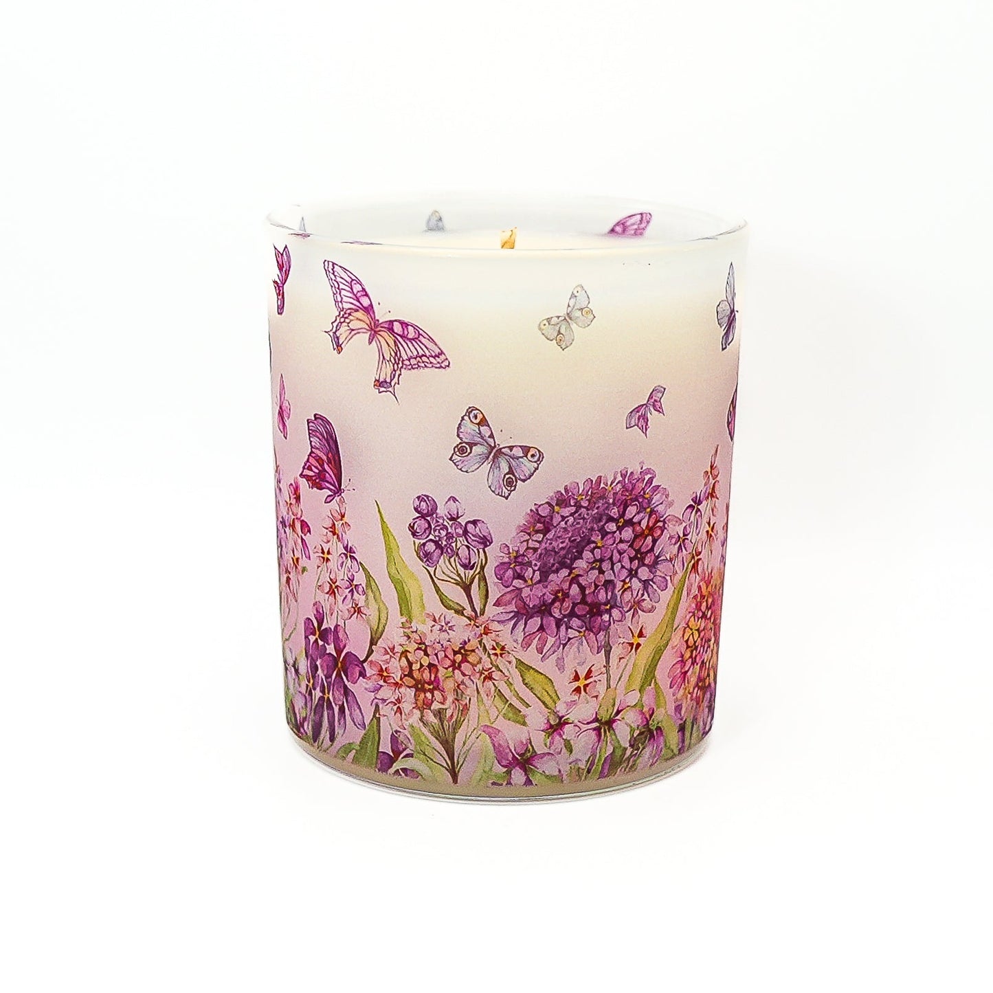 Hand-poured soy wax candle in frosted glass jar decorated with butterflies and floral botanical pattern.