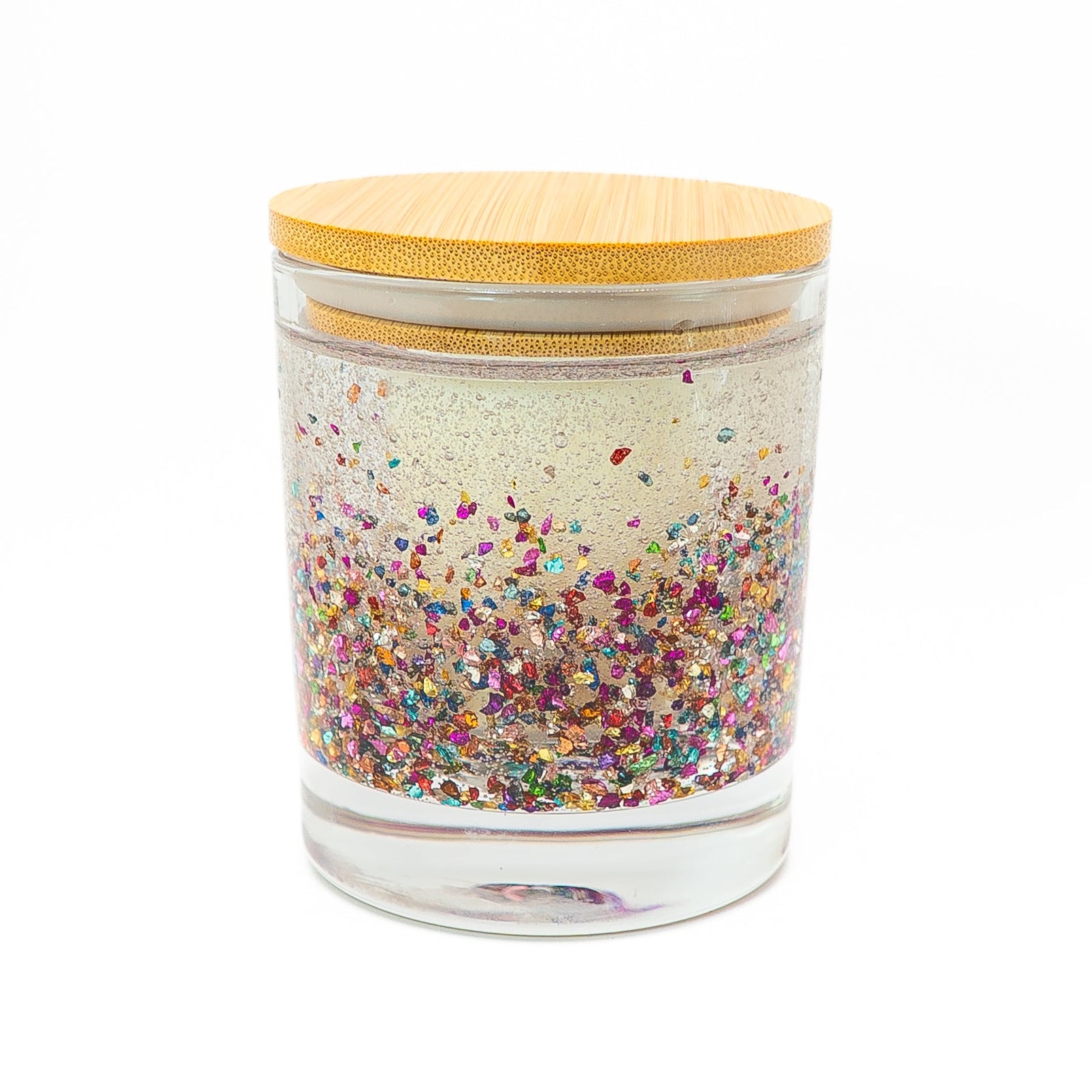 Hand-poured soy wax candle in a clear glass jar with colourful glitter and wooden lid.