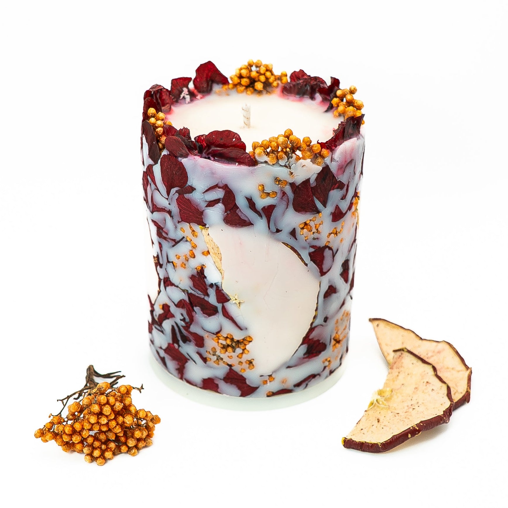 Hand-poured soy wax pillar candle embedded with dried hydrangea petals and red apple slices.