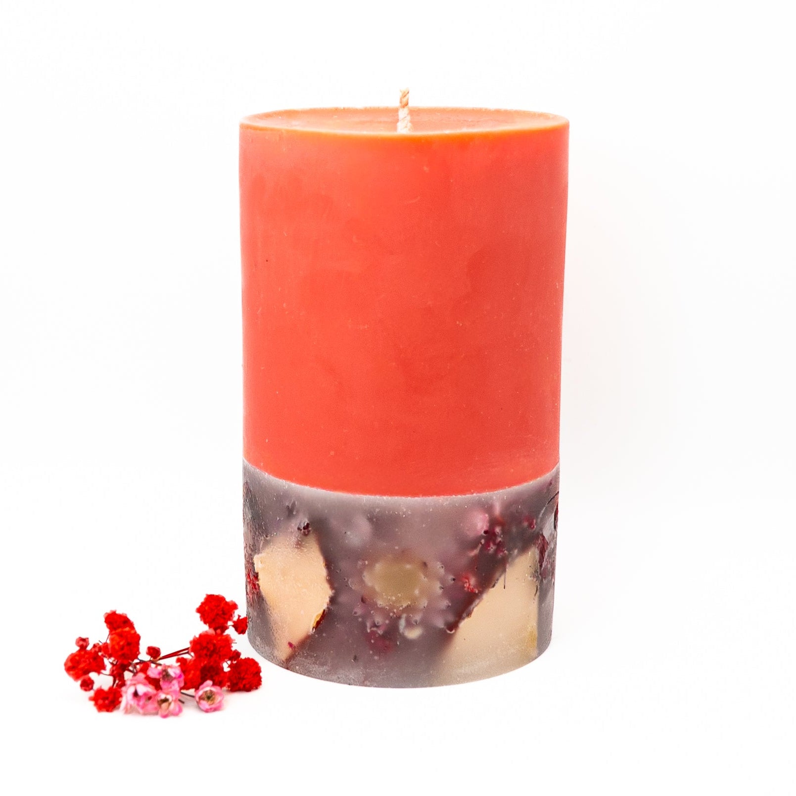 Hand-poured layered soy wax candle with red upper layer and dried flower botanicals below.
