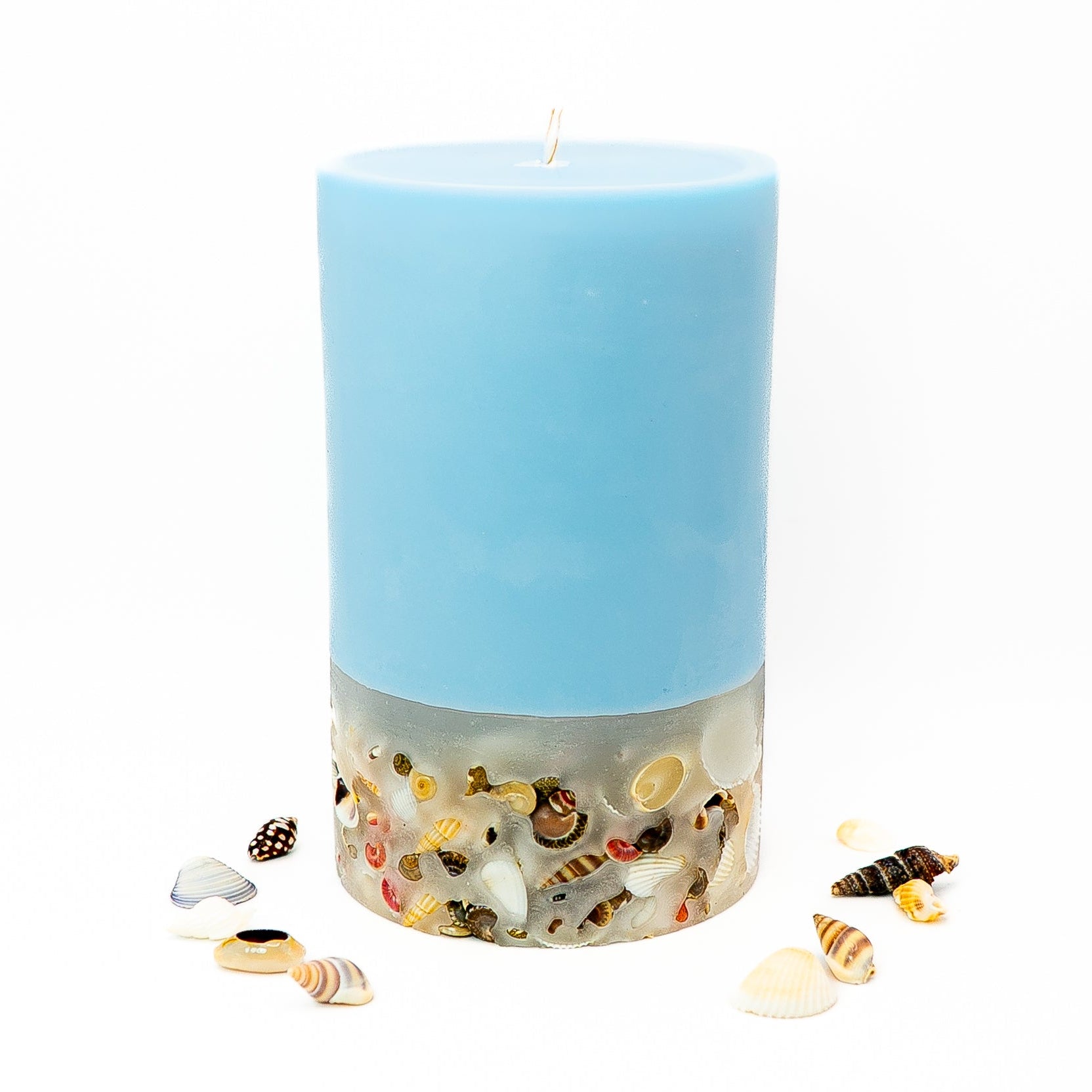Hand-poured coastal candle with layered soy wax and embedded seashell base.