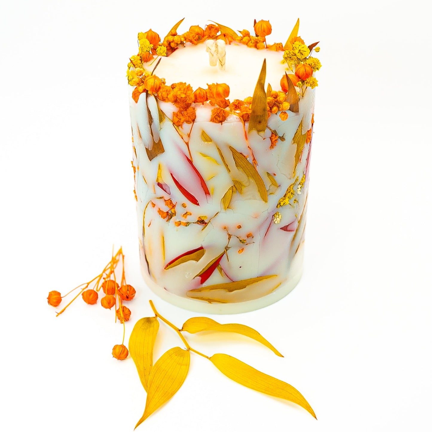 Hand-poured botanical candle with dried autumn flowers and leaves in natural soy wax.