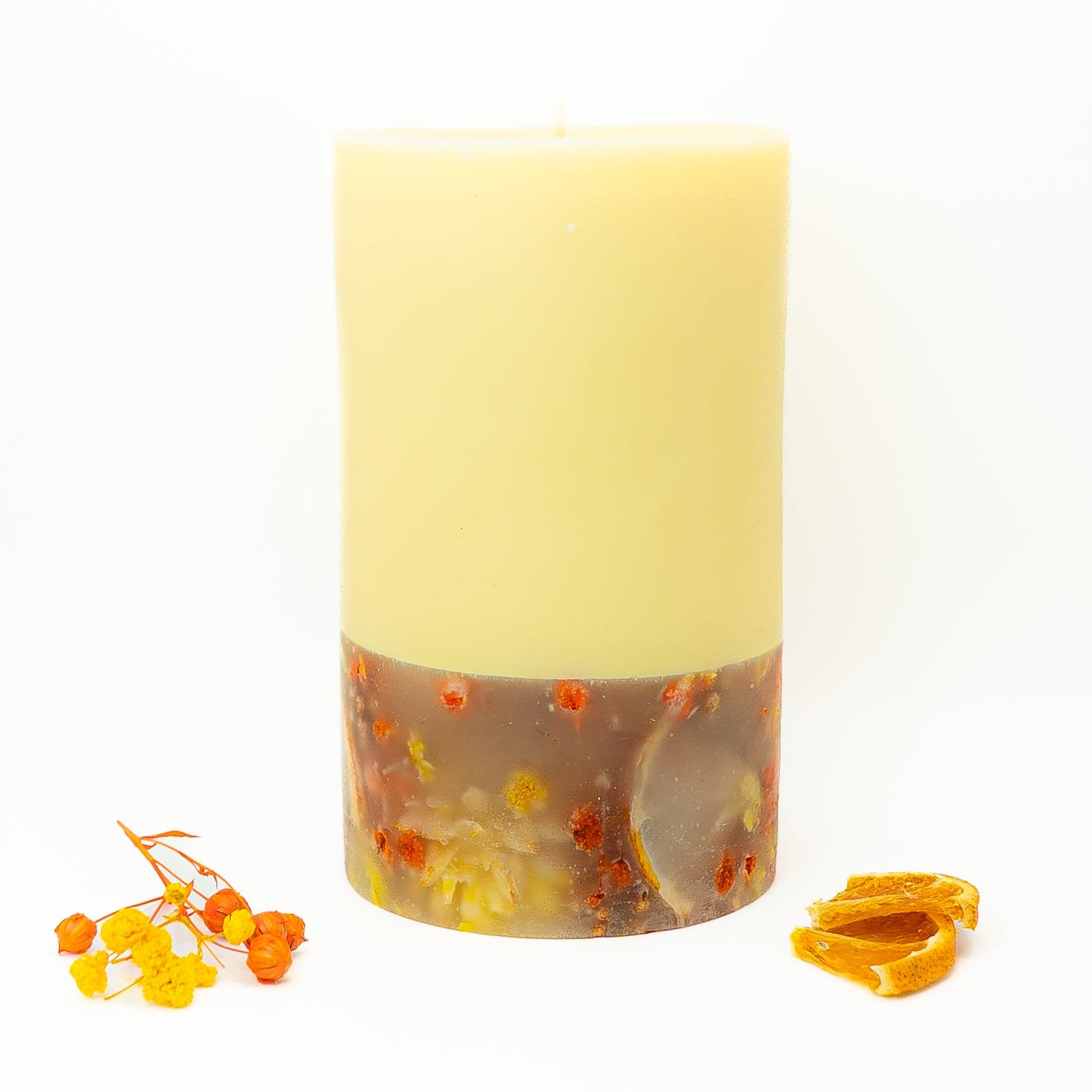 Handmade soy wax candle featuring dried citrus slices and small floral botanicals.