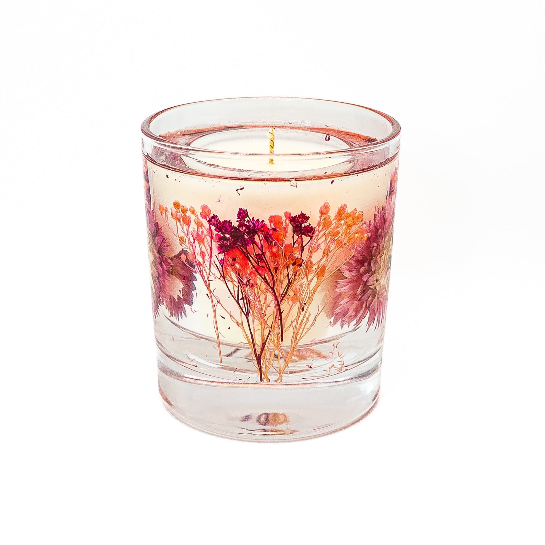 Soy wax candle with transparent gel wax decorated with a preserved pink helichrysum flower in a glass jar.