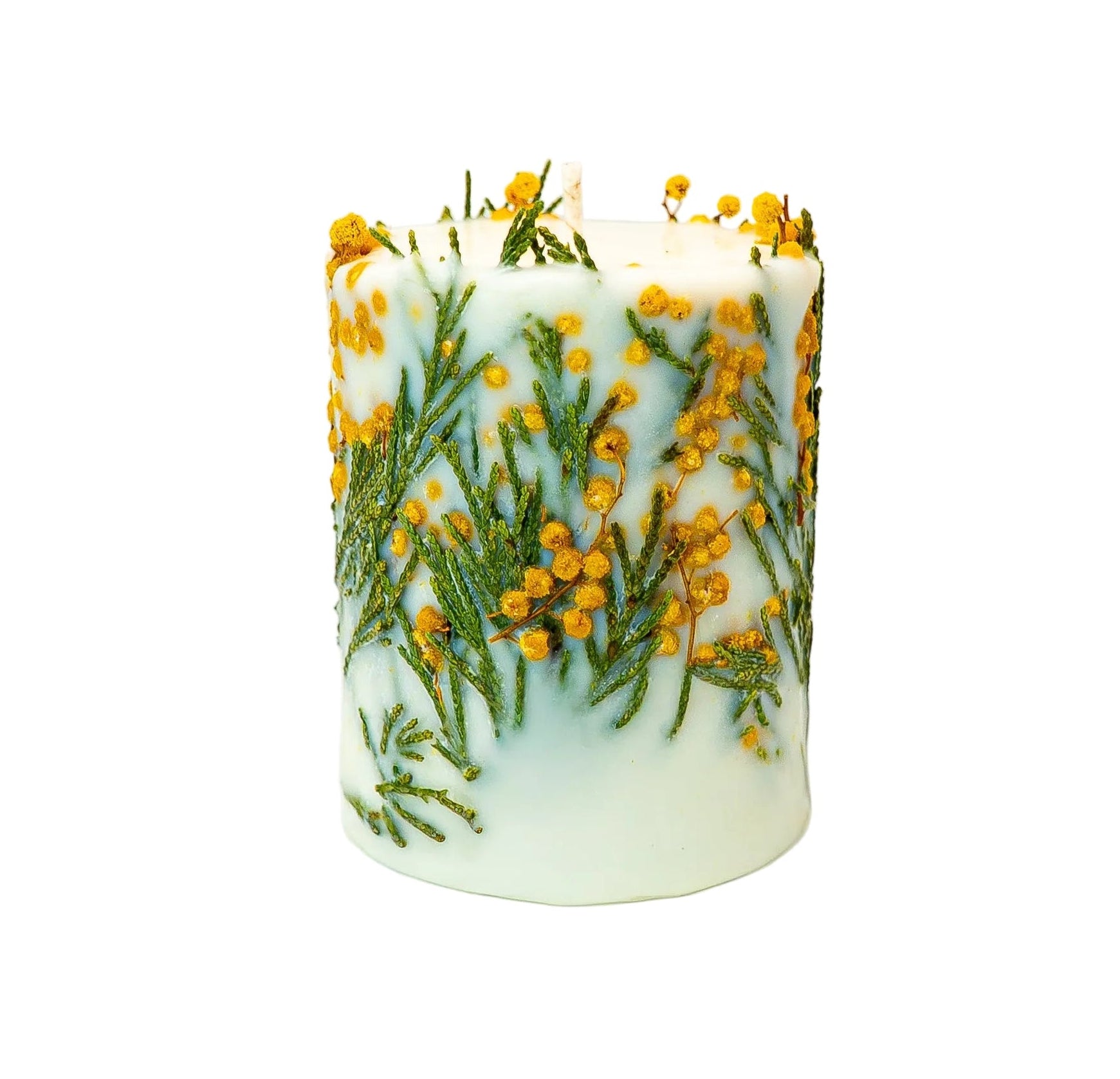 Cylindrical white soy wax candle featuring dried mimosa flowers and green fern pressed into the wax