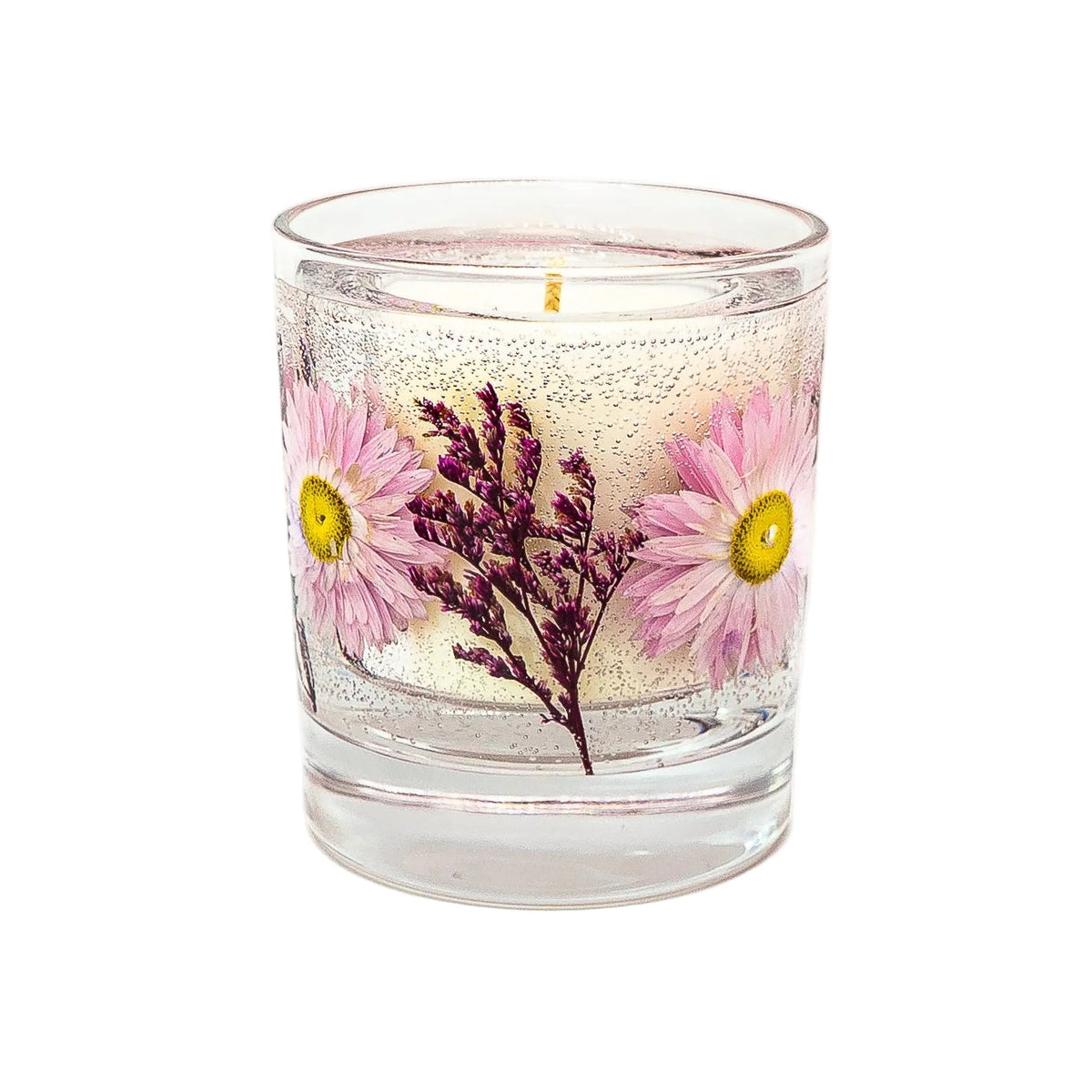 Close-up of a botanical container candle with pink dried flowers and purple sprigs in clear gel wax surrounding a soy wax centre in a round glass jar.