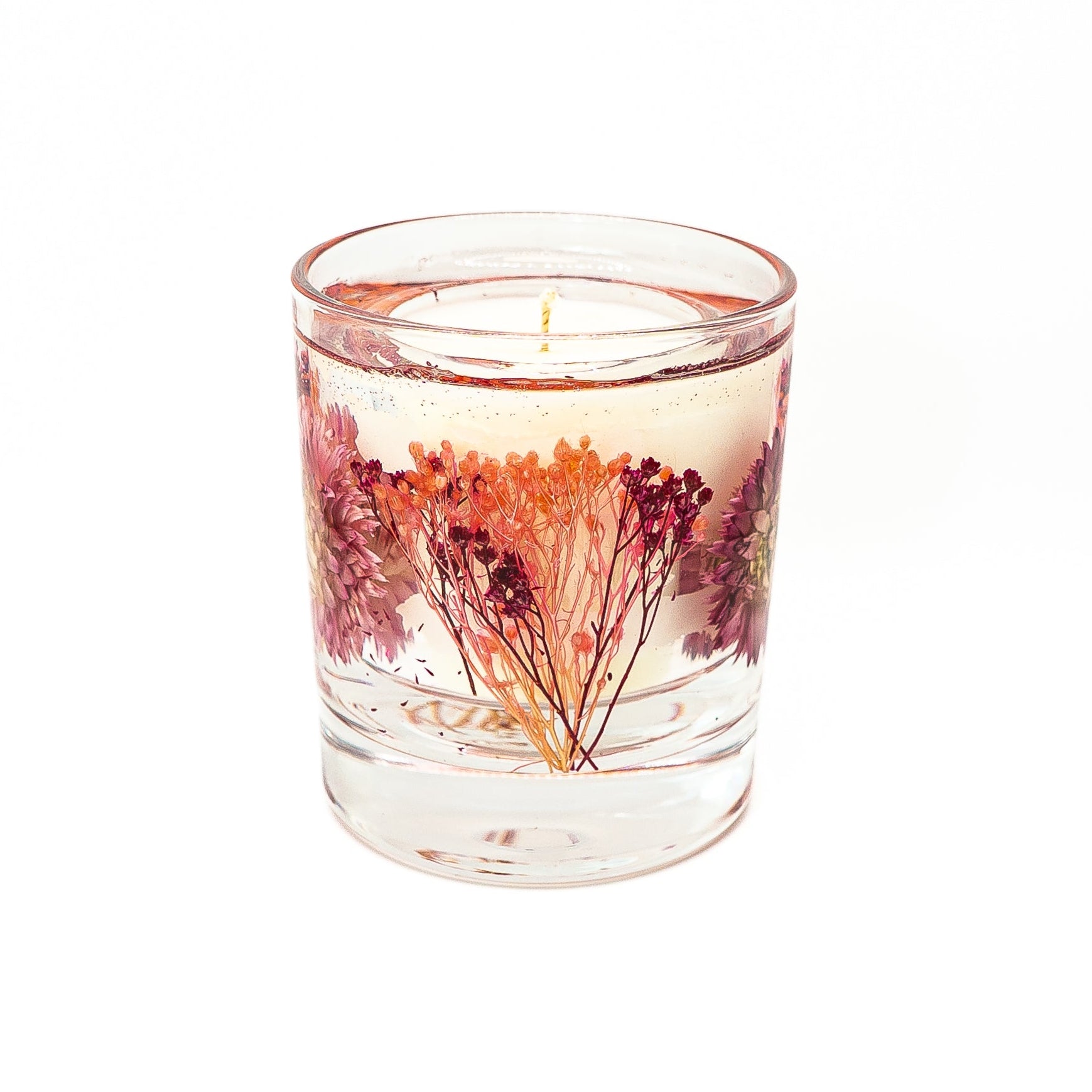 Decorative candle with soy wax center and gel wax outer layer featuring a pink helichrysum flower.