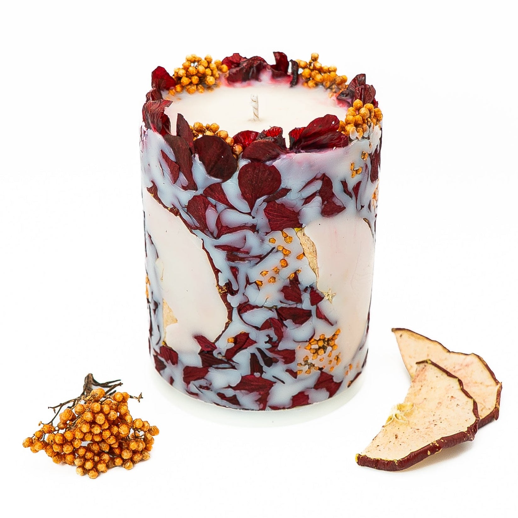 Hand-poured soy wax botanical pillar candle with dried hydrangea petals and red apple slices.