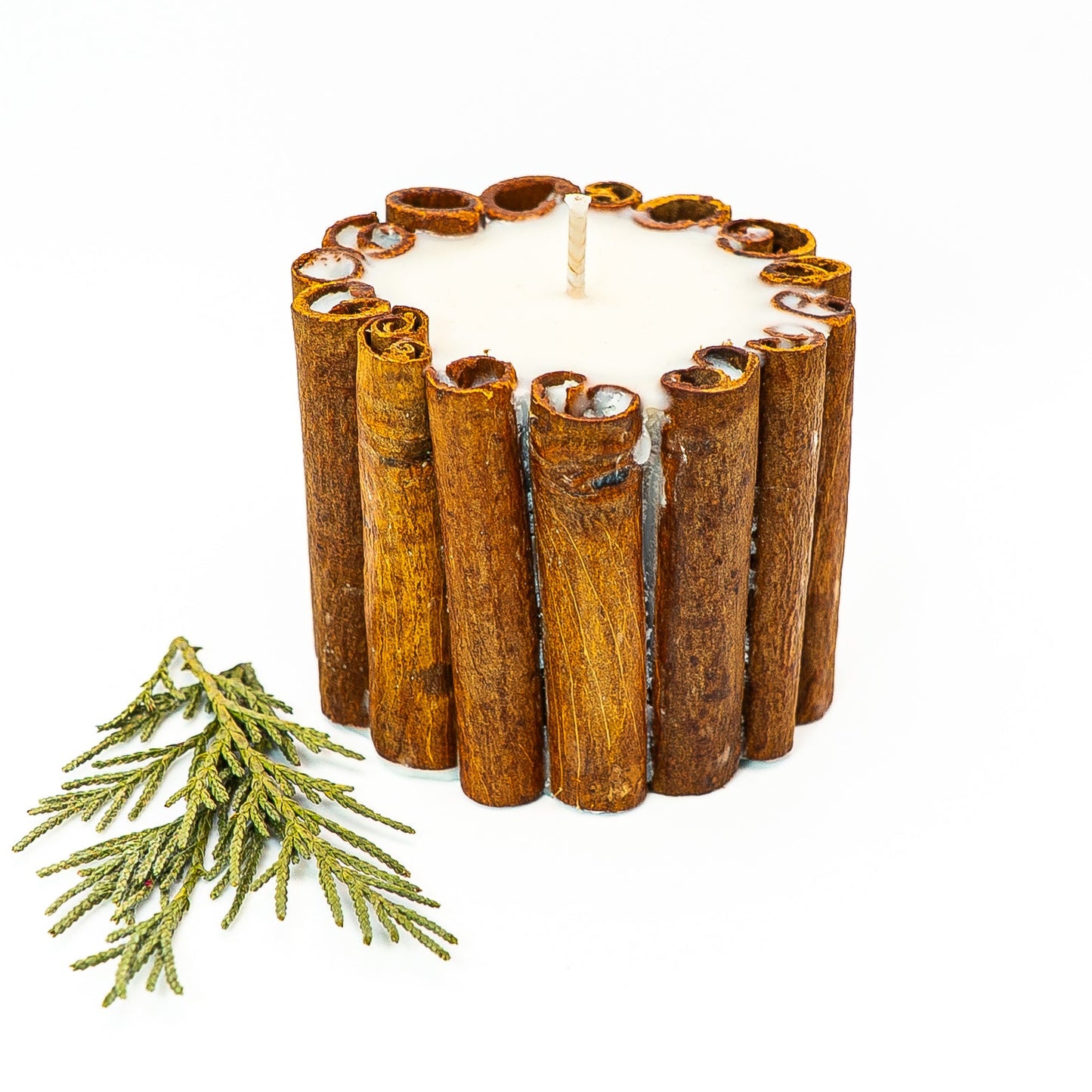 Rustic soy wax pillar candle with whole cinnamon sticks arranged around the candle exterior.