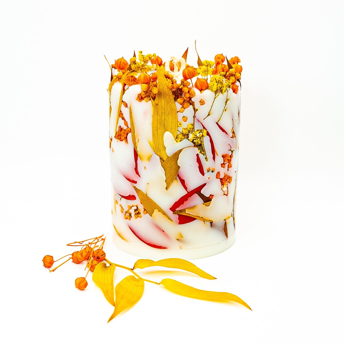 Seasonal autumn botanical candle with dried flowers and leaves embedded in hand-poured soy wax.
