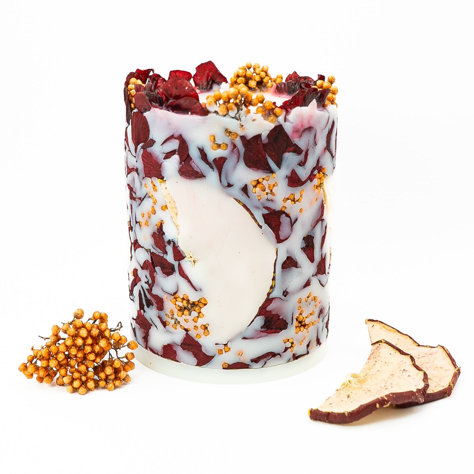 Seasonal botanical soy wax pillar candle with hydrangea petals and dried red apple slices.