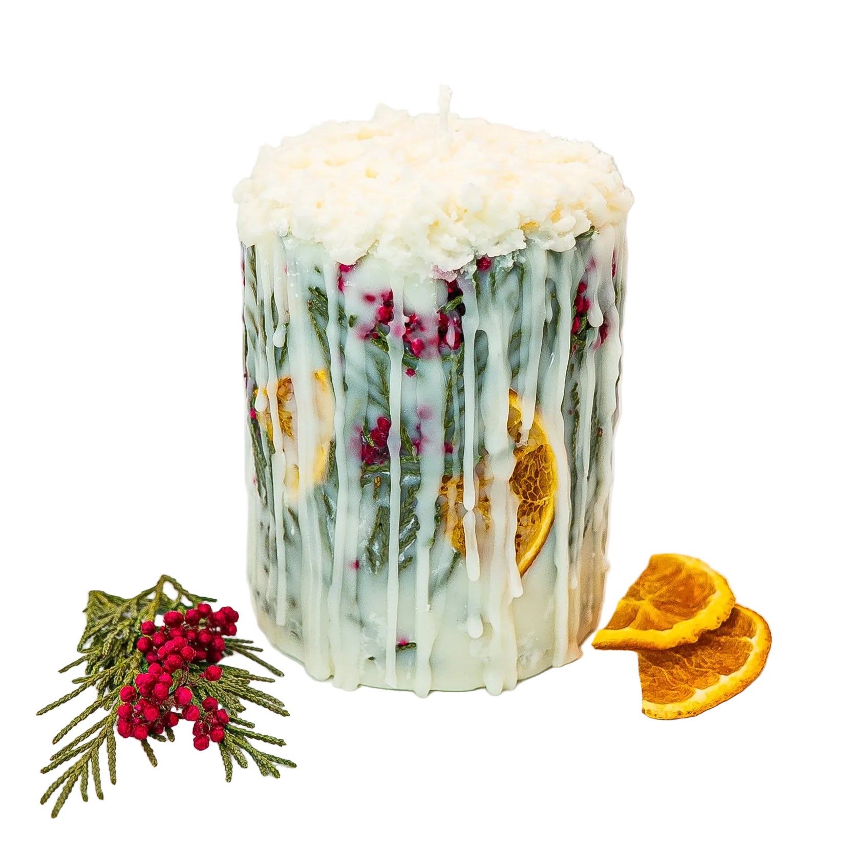 Seasonal botanical pillar candle with dried citrus, evergreen branches, and red berries.