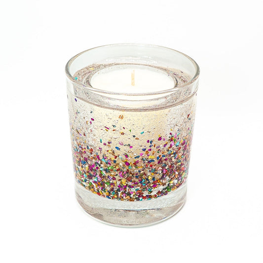 Decorative candle with colourful glitter gel wax surrounding a soy wax core in a clear glass container.
