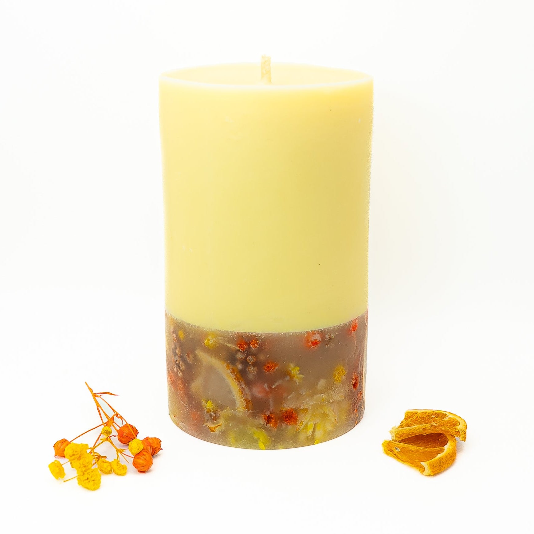 Sun-inspired soy wax pillar candle with yellow wax top and citrus botanical base.