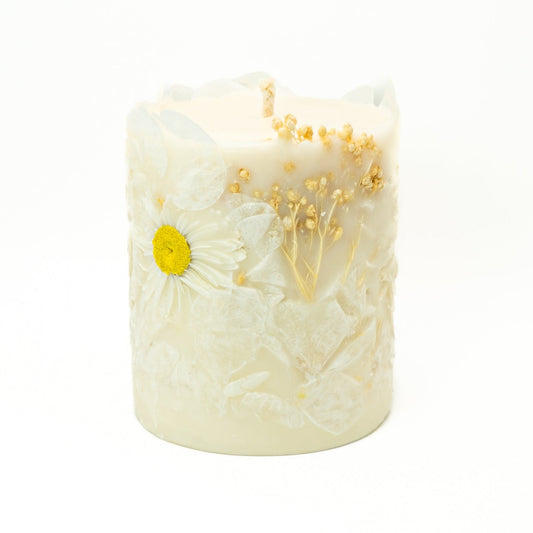 Hand-poured soy wax botanical pillar candle with white Acroclinium flowers embedded in wax.